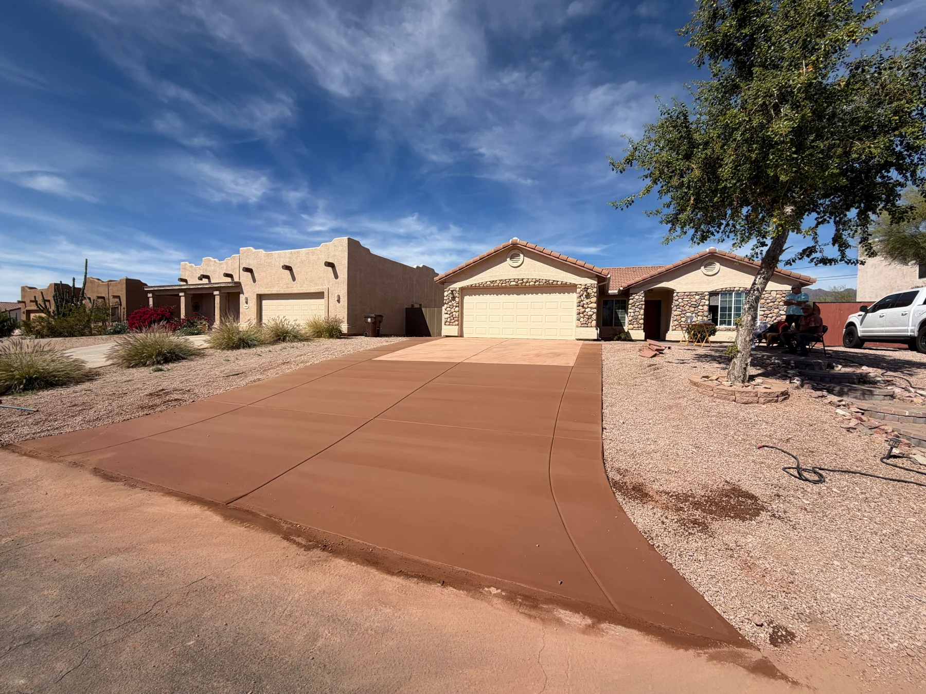Warm terracotta concrete driveway in front of a stucco Arizona home